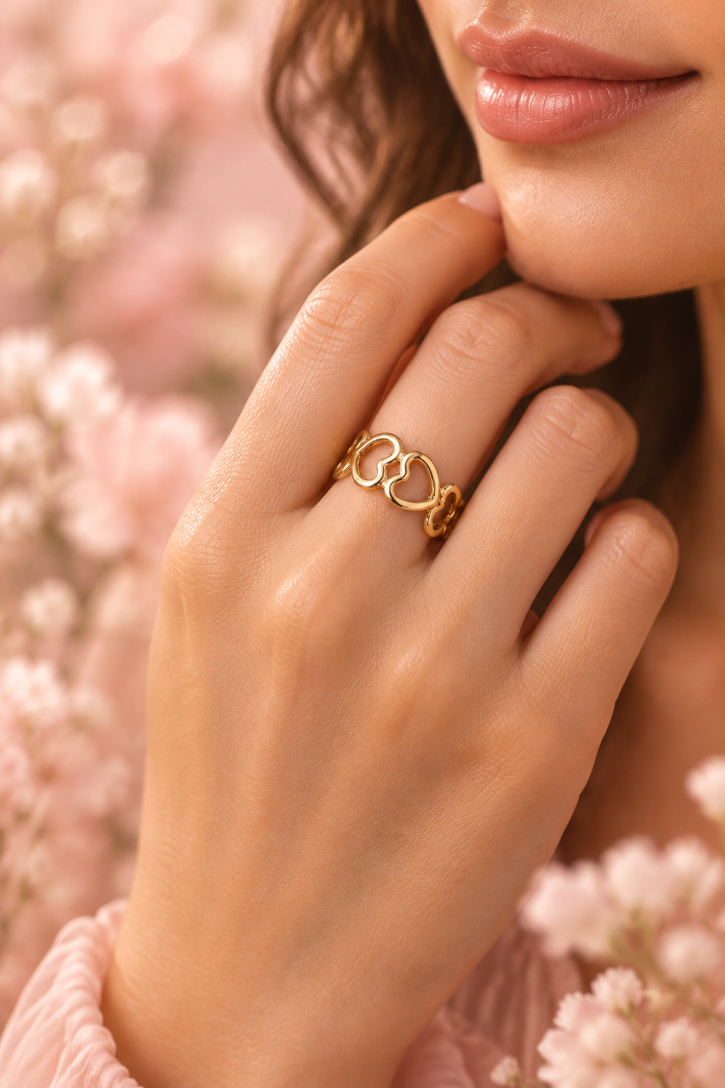 Gold heart ring on model blush pink background